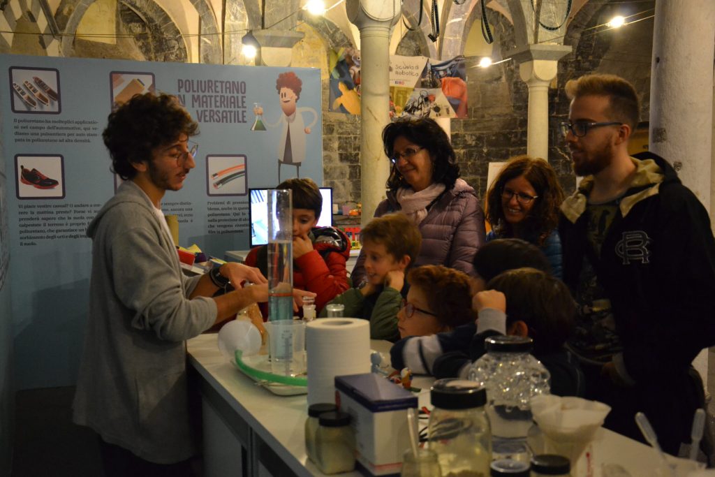 Un animatore conduce un esperimento davanti al pubblico della mostra Prototype