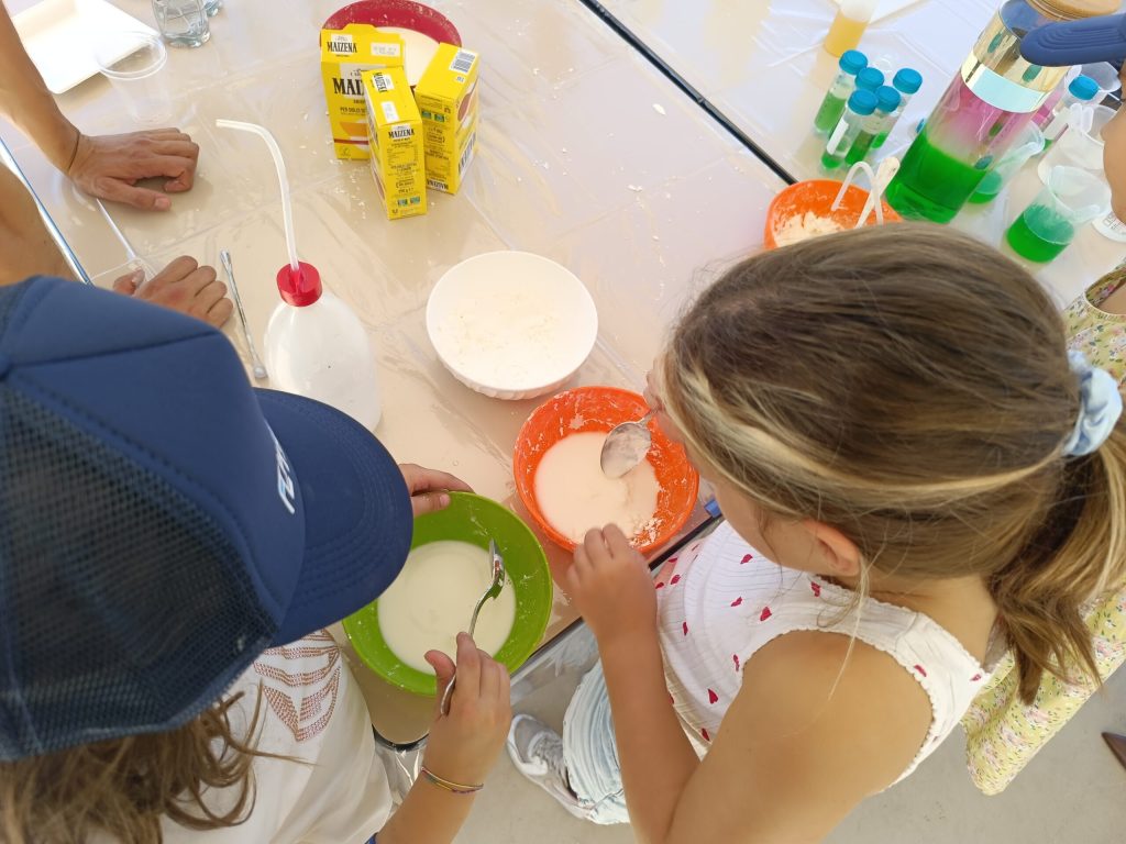 Due bambini alle prese con i materiali del laboratorio, visti dall'alto