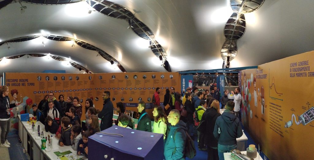 Studenti in visita all'allestimento Katalysis, lungo i pannelli della mostra