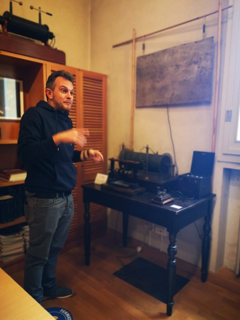 Un divulgatore accanto al tavolo degli strumenti radio del museo