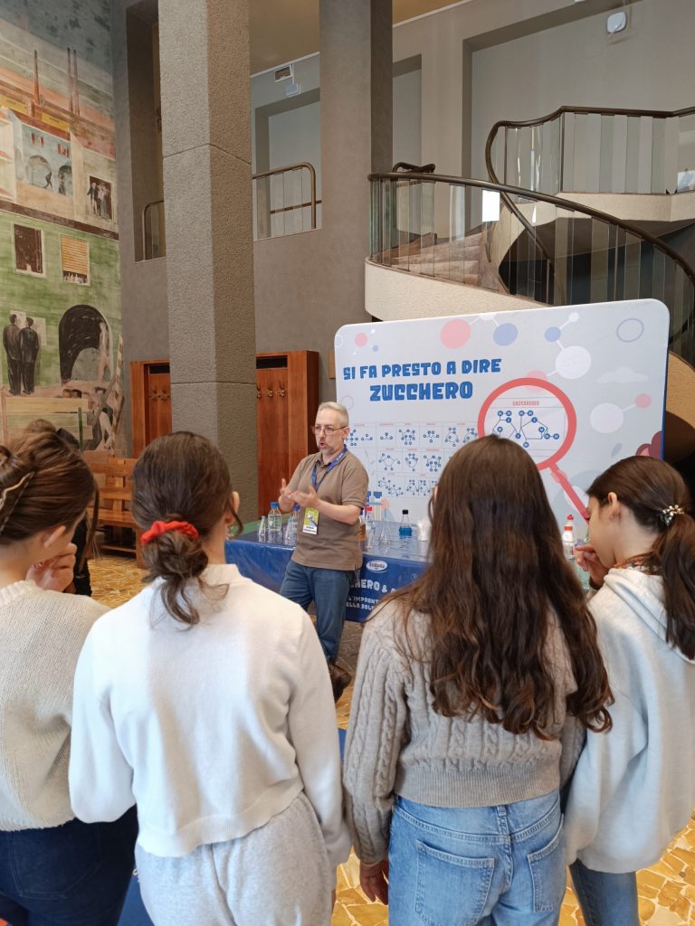 Ragazzi davanti al pannello illustrato del laboratorio sullo zucchero